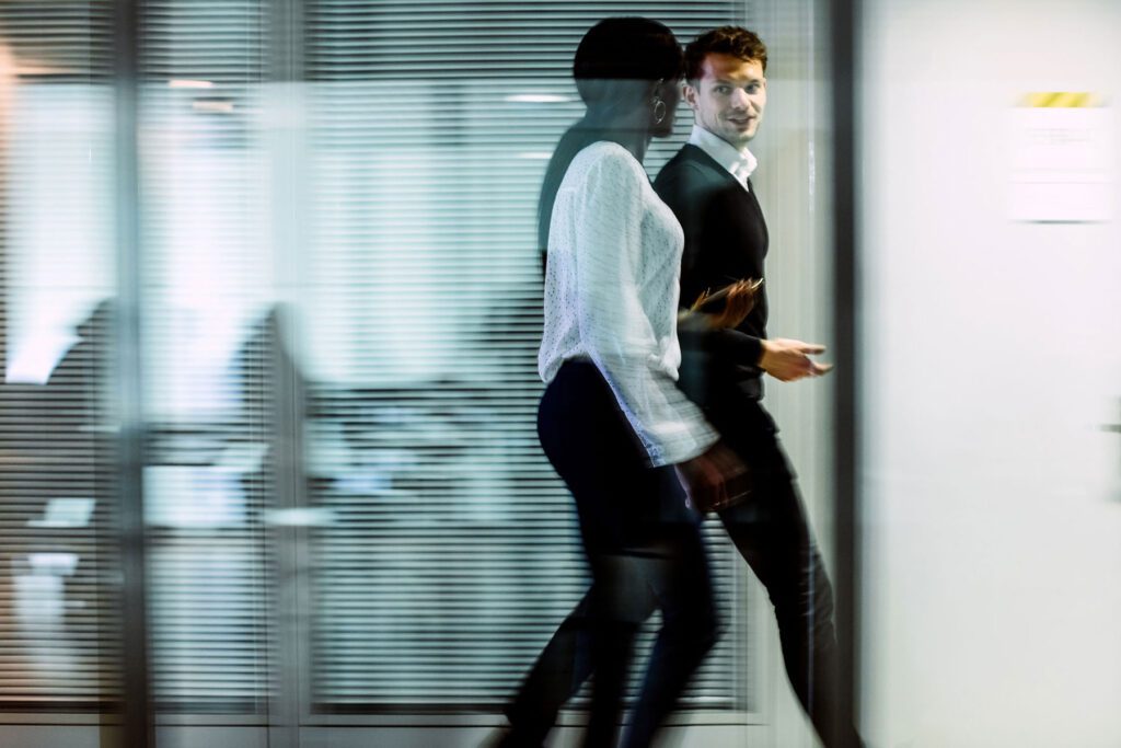 Two people talking and walking hallway