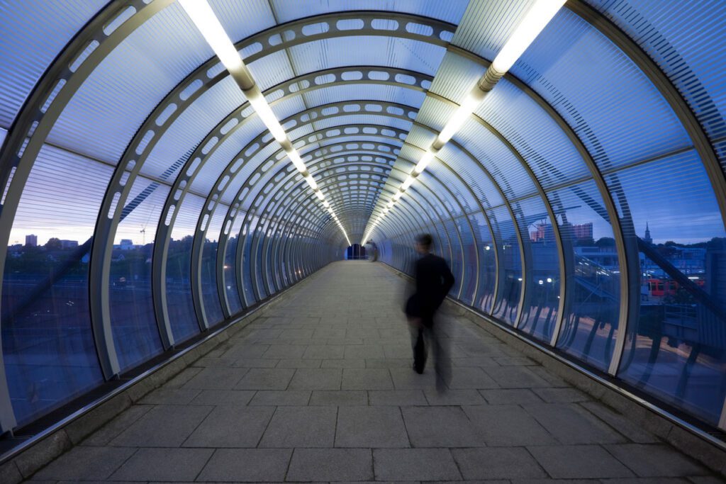 Business commuter on urban elevated walkway at dusk