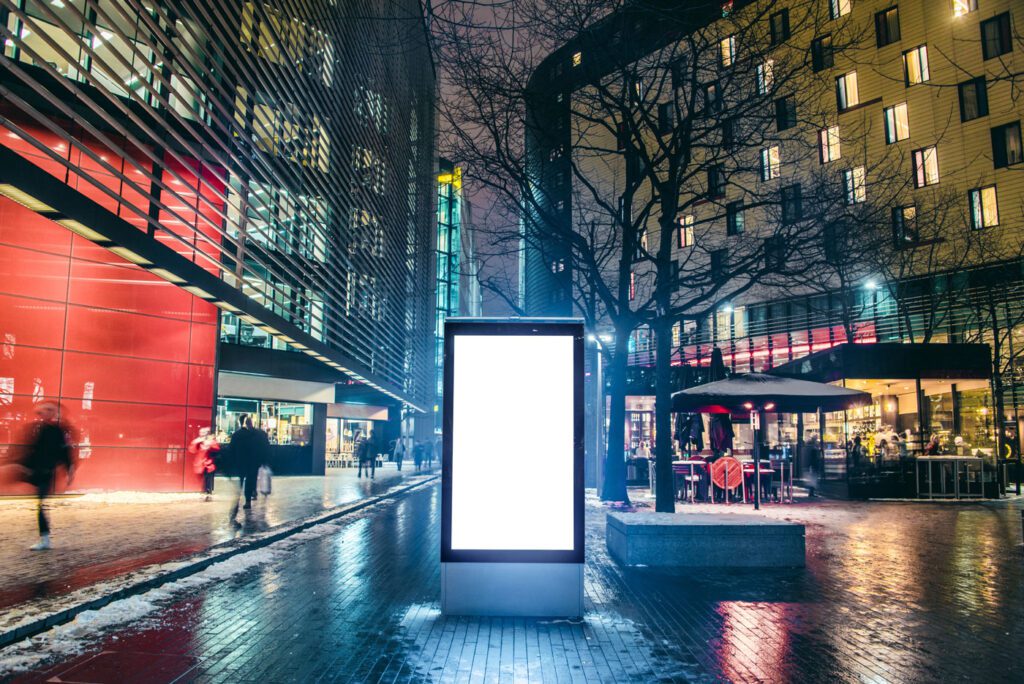 An illuminated blank billboard at night