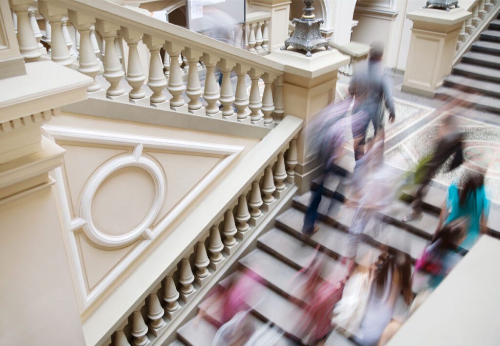 People walking up historic staircase