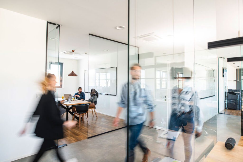 People sat in meeting room with busy hallway