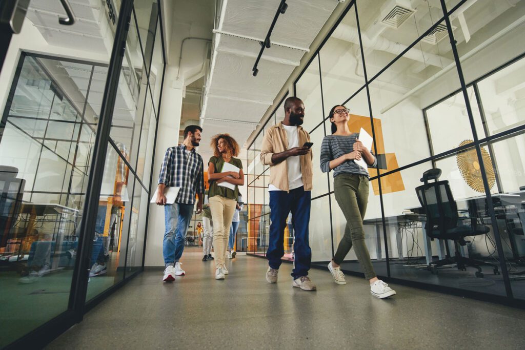 Smiling coworkers walking in office hallway