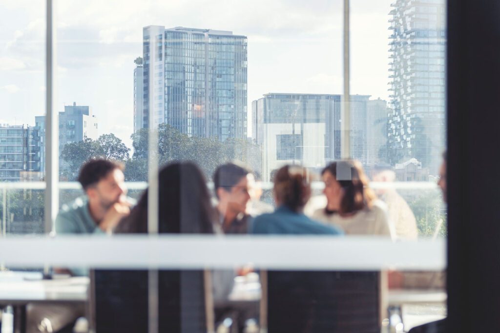 Team meeting in blurry office with view of city behind them