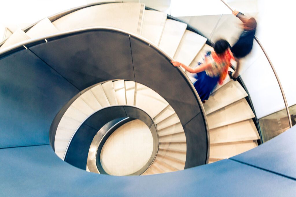 People walking up spiral staircase