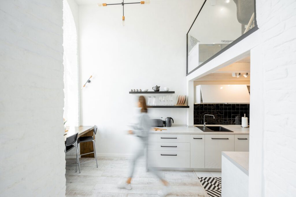 Interior view of the bright and modern kitchen with a blurred in motion human figure