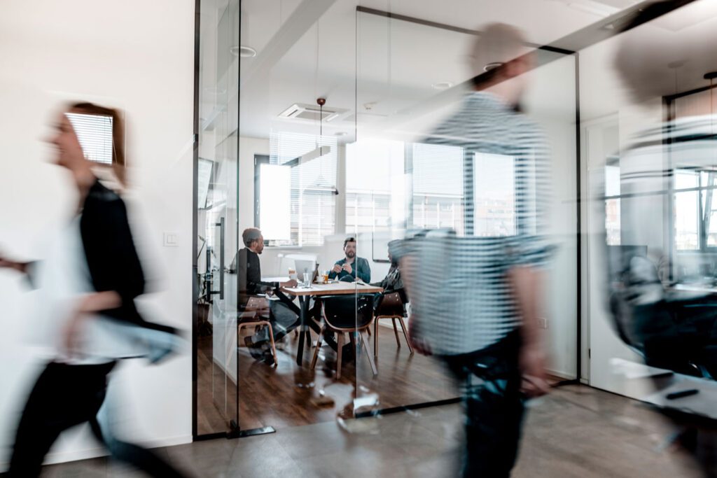 Busy hallway with group of people in office behind them