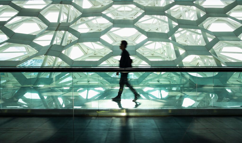 Man walking in front of abstract building