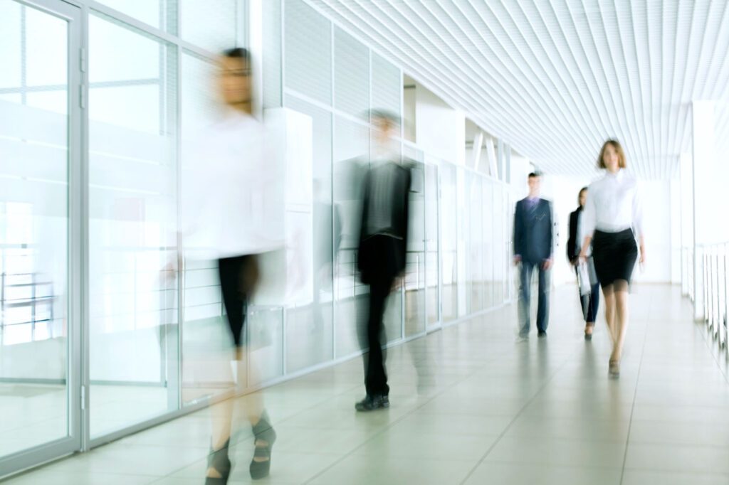 Blurry image of people walking through office hallway