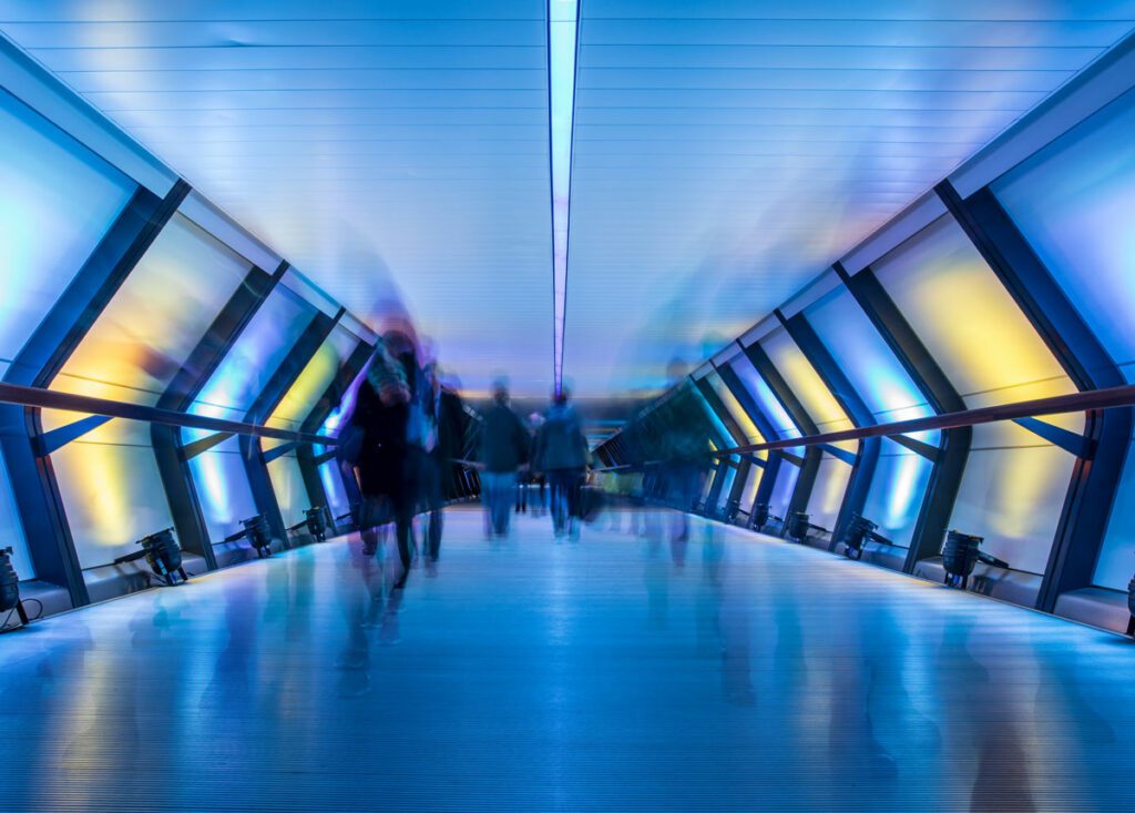 Description Crossrail at night with people in motion