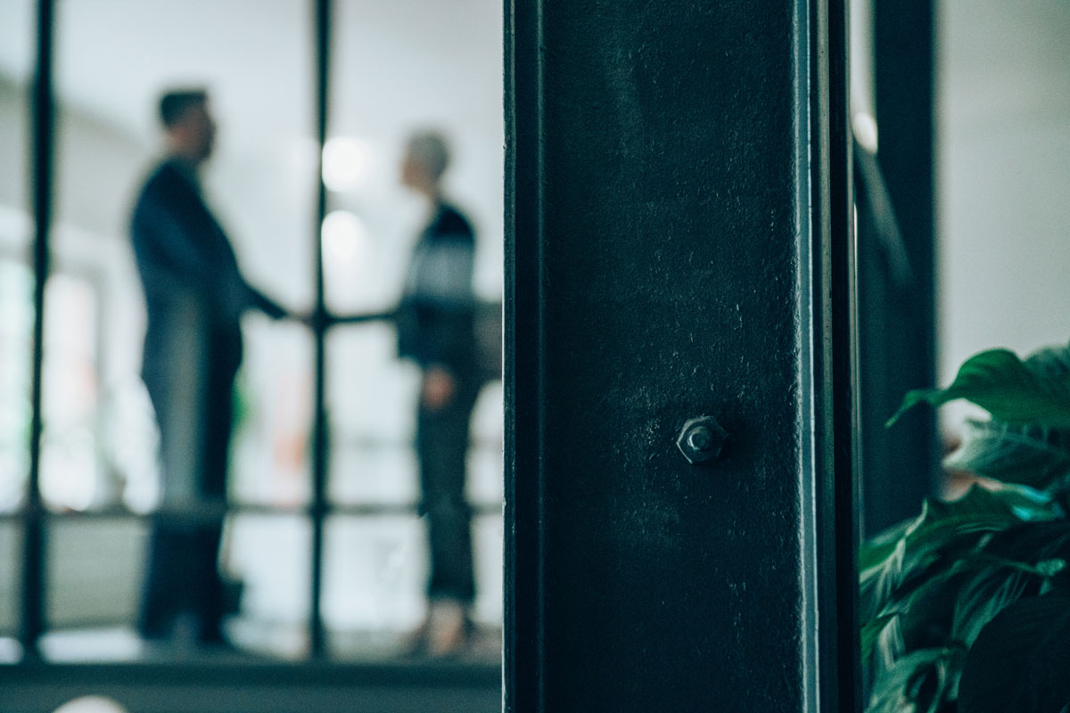 People shaking hands in office. Out of focus