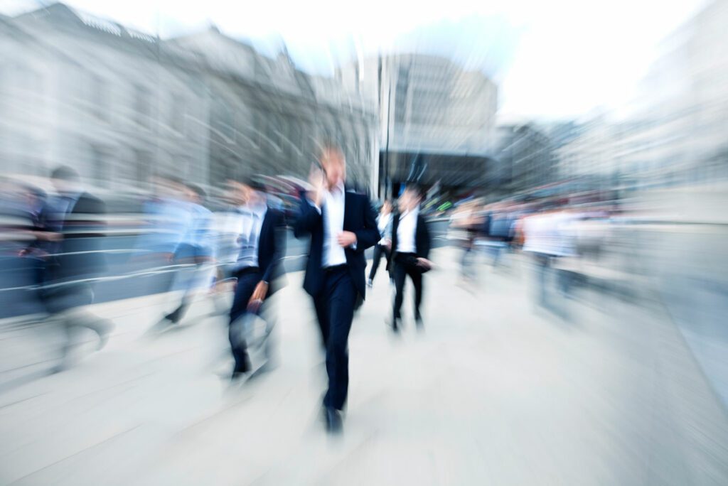 blurred view of business people walking fast in financial district,