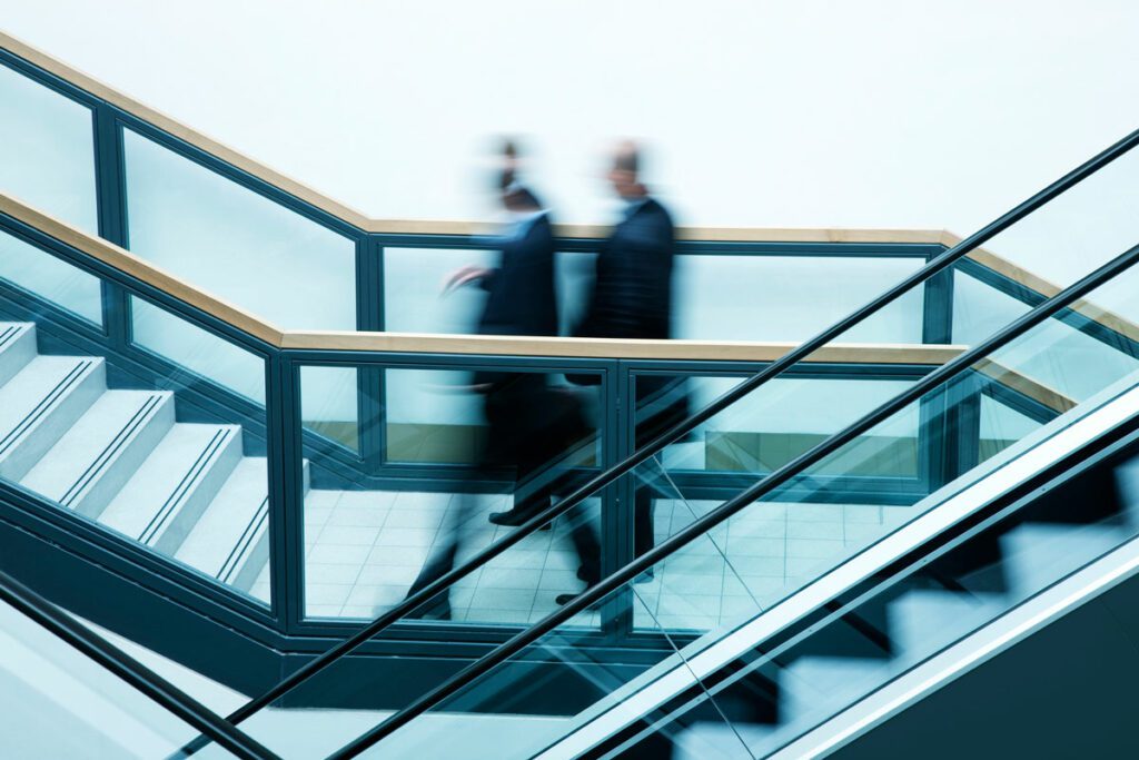 a group of motion blurred business people on the stairs, blue toned image