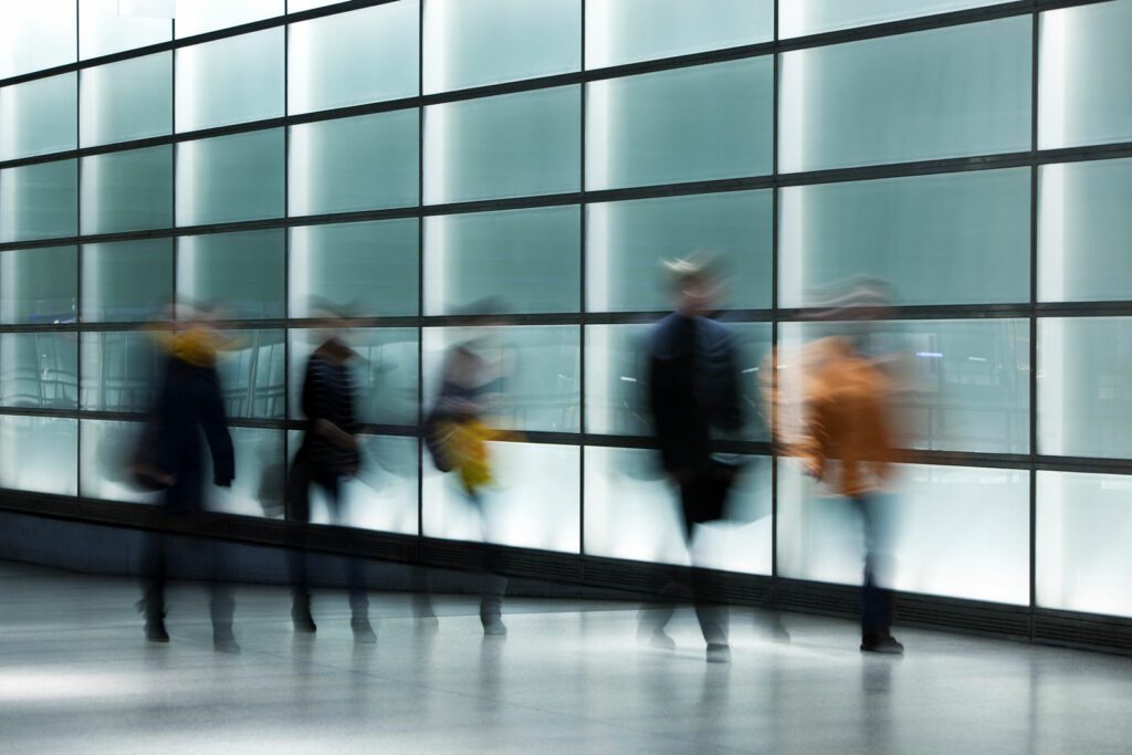 People Walking Against Illuminated Glass Wall