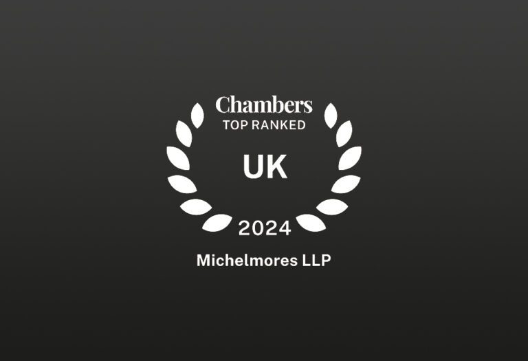 White laurel wreath with text inside: Chambers UK 2024 TOP RANKED Michelmores LLP on a dark background.