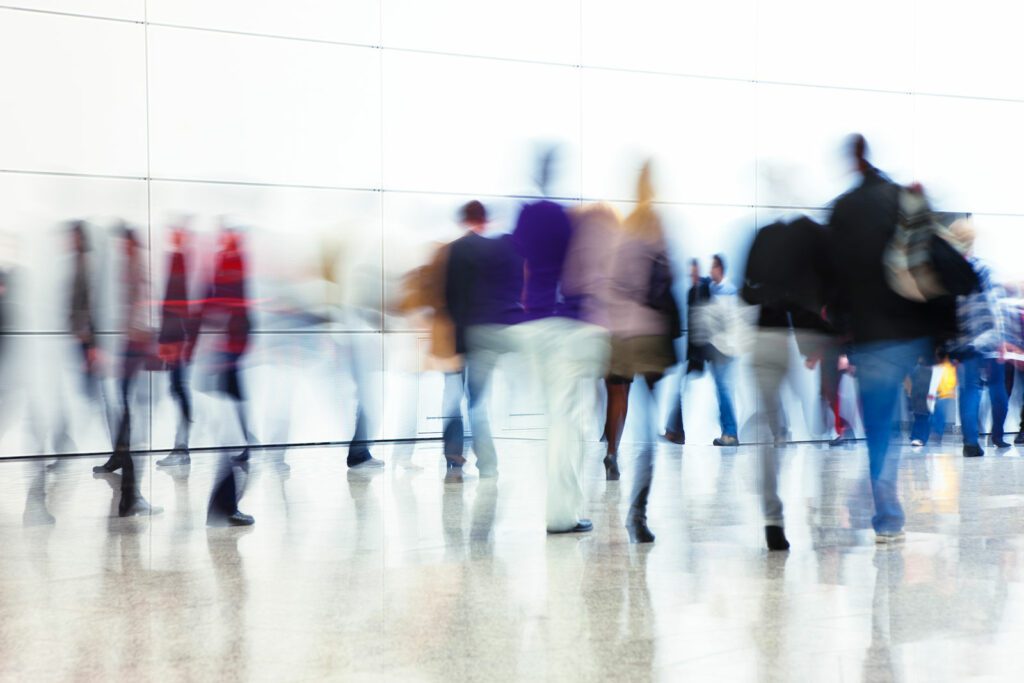 Crowd of People Walking Indoors Down Walkway, Blurred Motion