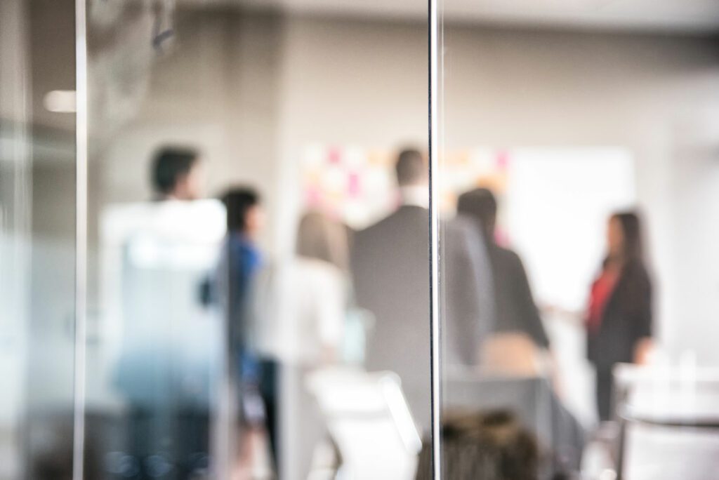 Abstract of a corporate team meeting in an glass office conference room.