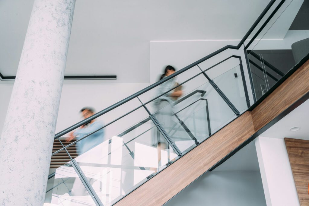 Shot of two business persons in a blurred motion on stairs in the office.