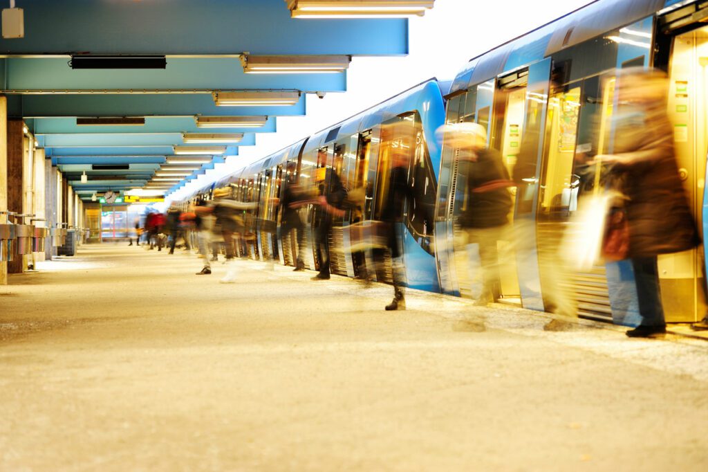 People congestion when motion blurred travellers departs subway train at platform.