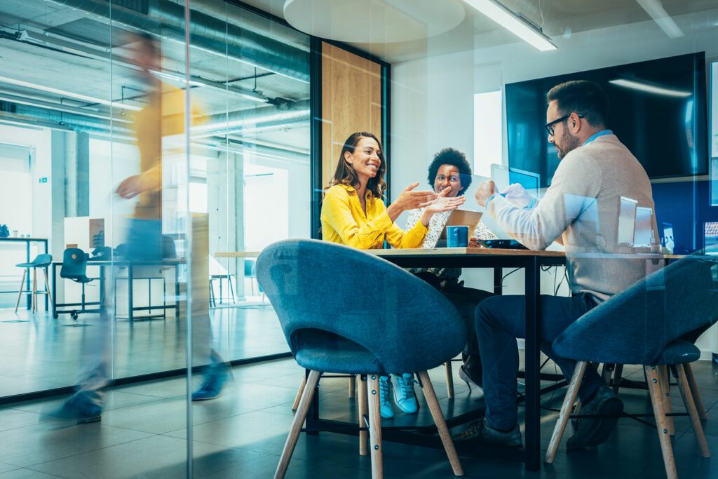 Businesspeople in Conference Room and Colleagues Walking By