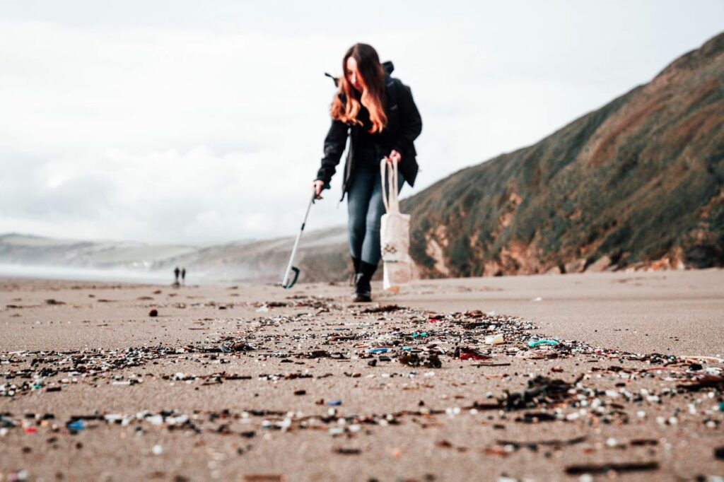 Someone picking up litter on a beach