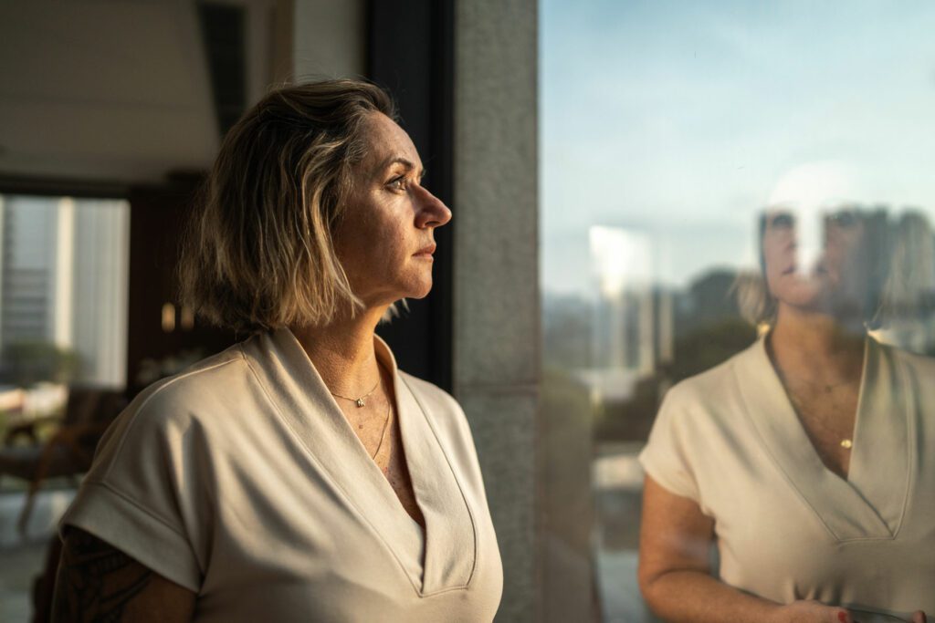 Contemplative mature woman looking through the window