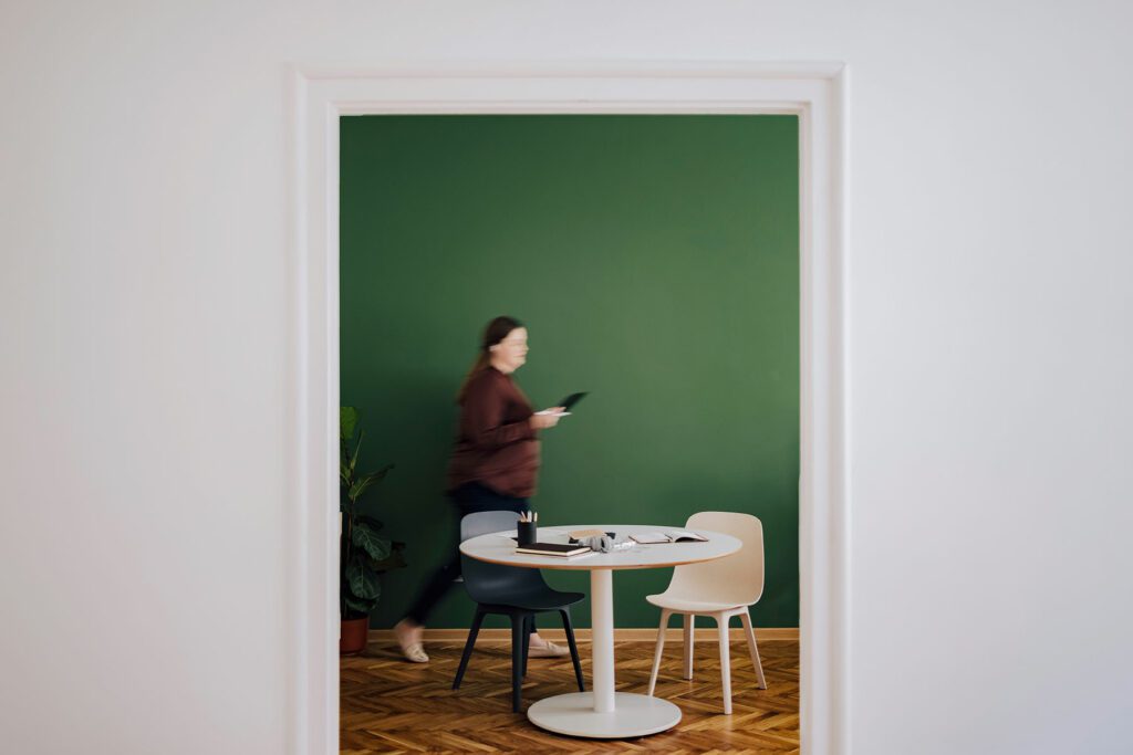Unrecognizable woman holding her digital tablet while walking at her office.