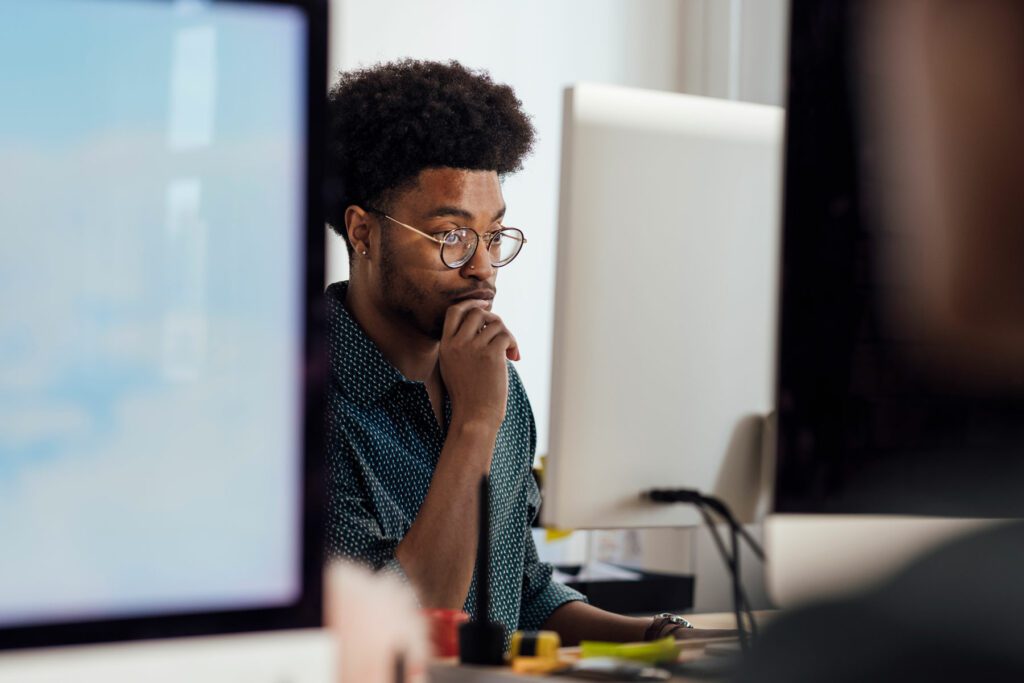 Close-up of a young male with an afro at an office desk