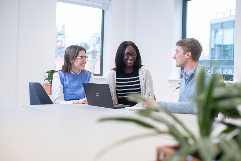 Three people working in bright modern office
