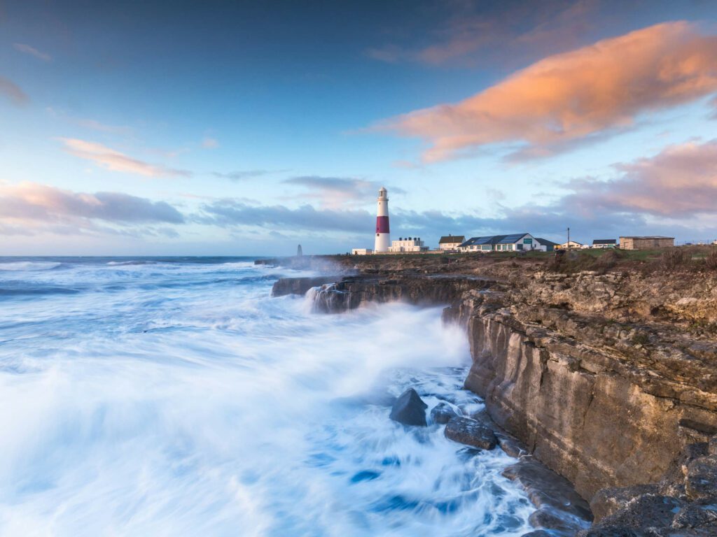 Lighthouse with waves crashing on cliffs