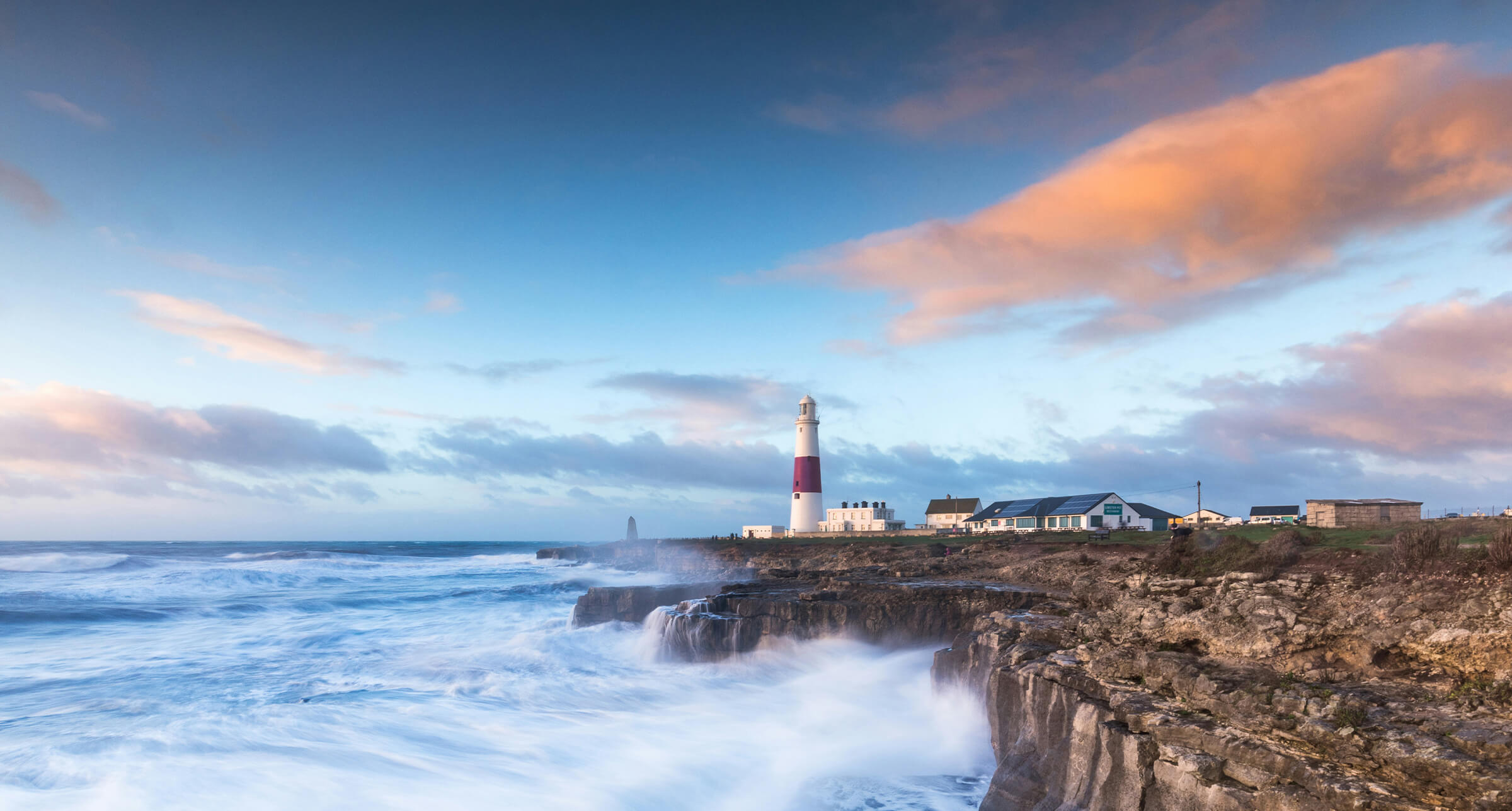 Lighthouse with waves crashing on cliffs