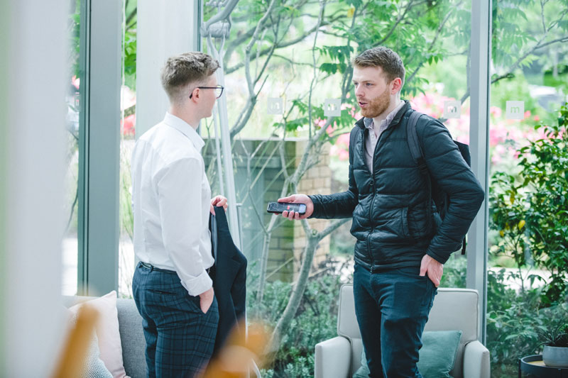 Two Michelmores colleagues talking in bright office space