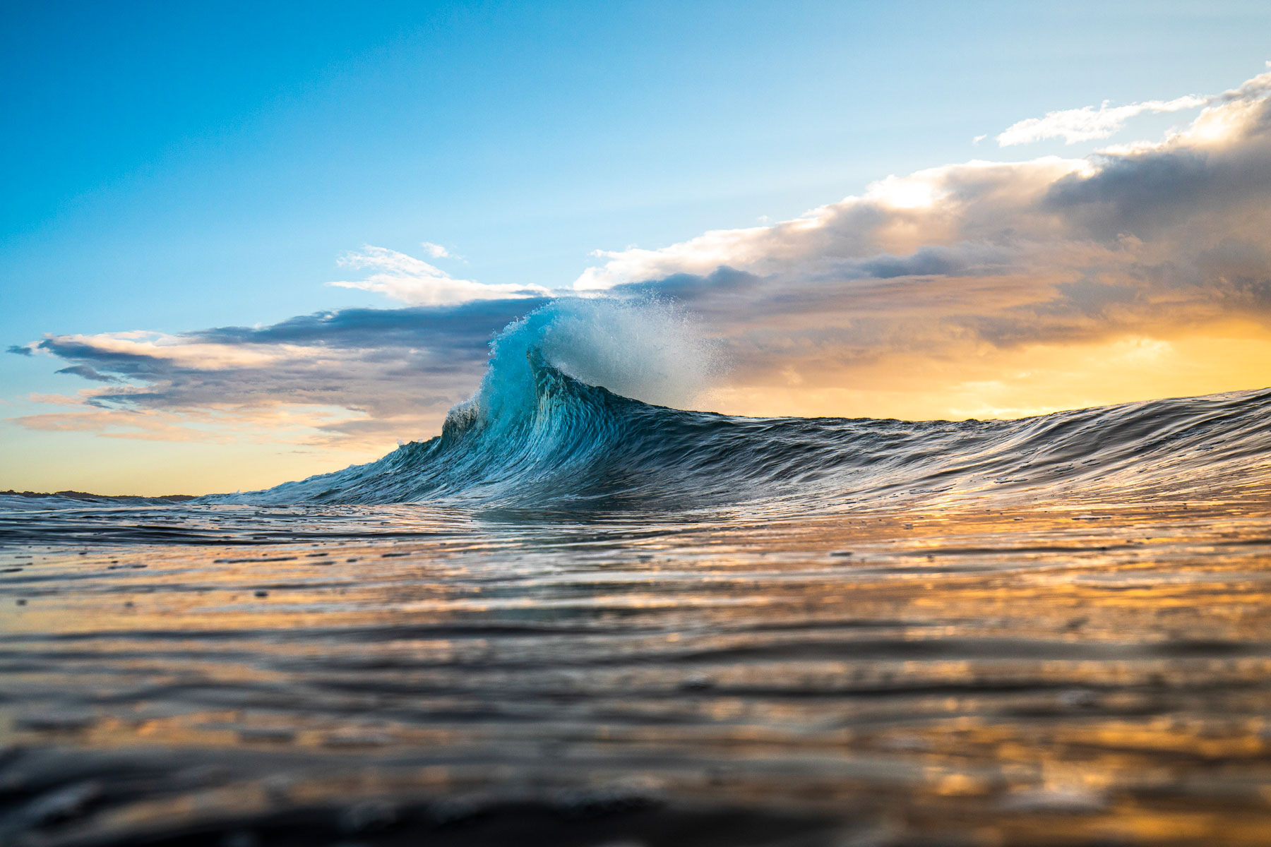 Wave breaking while the sun is setting