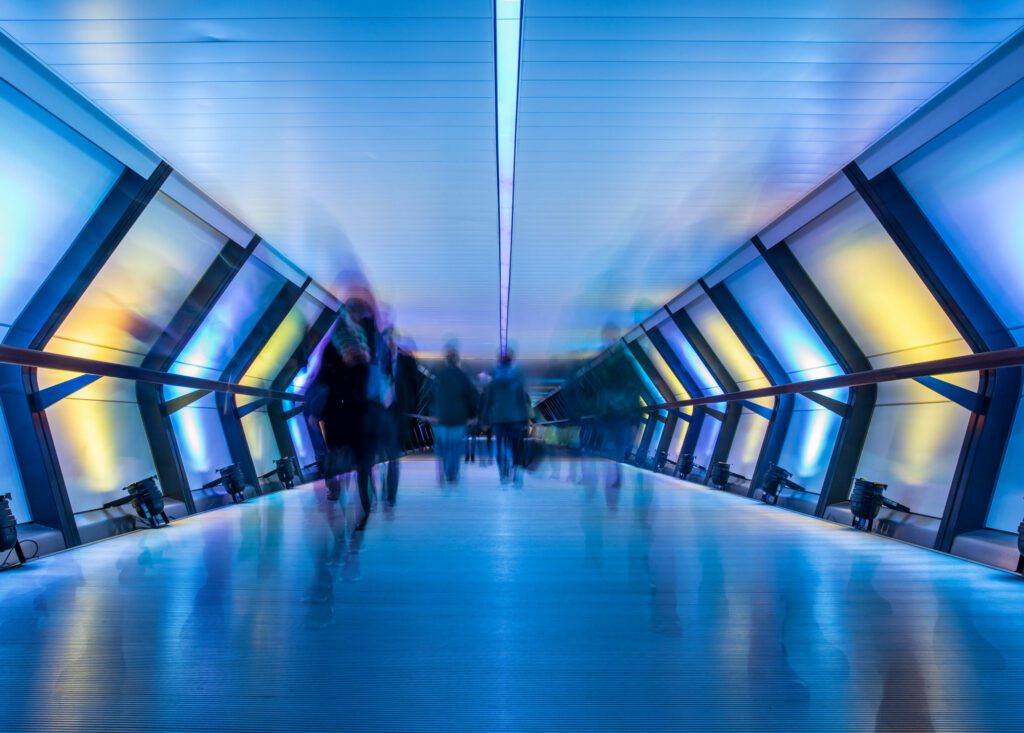 blurred people walking through tunnel