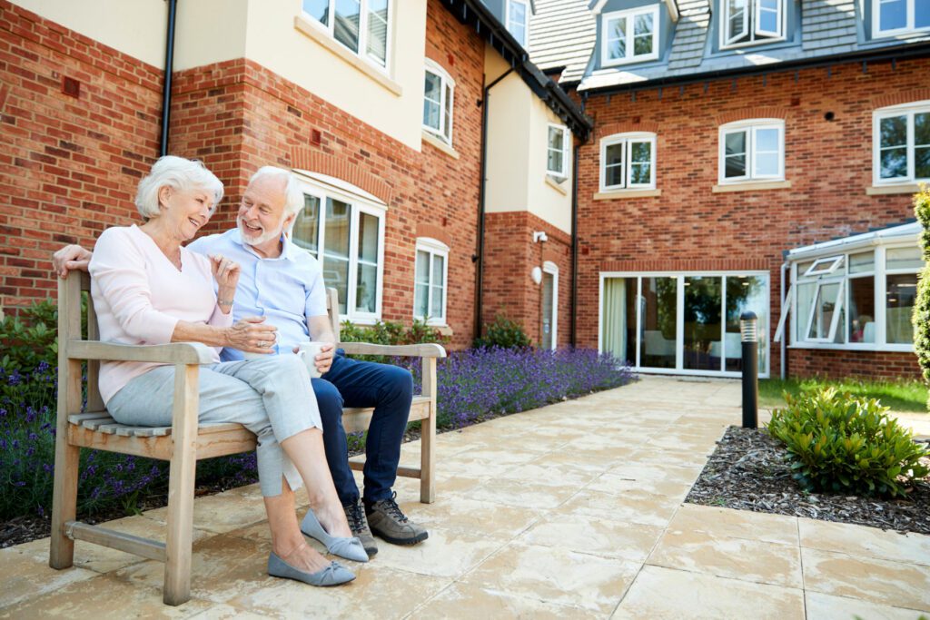 Couple sat on bench in retirement village