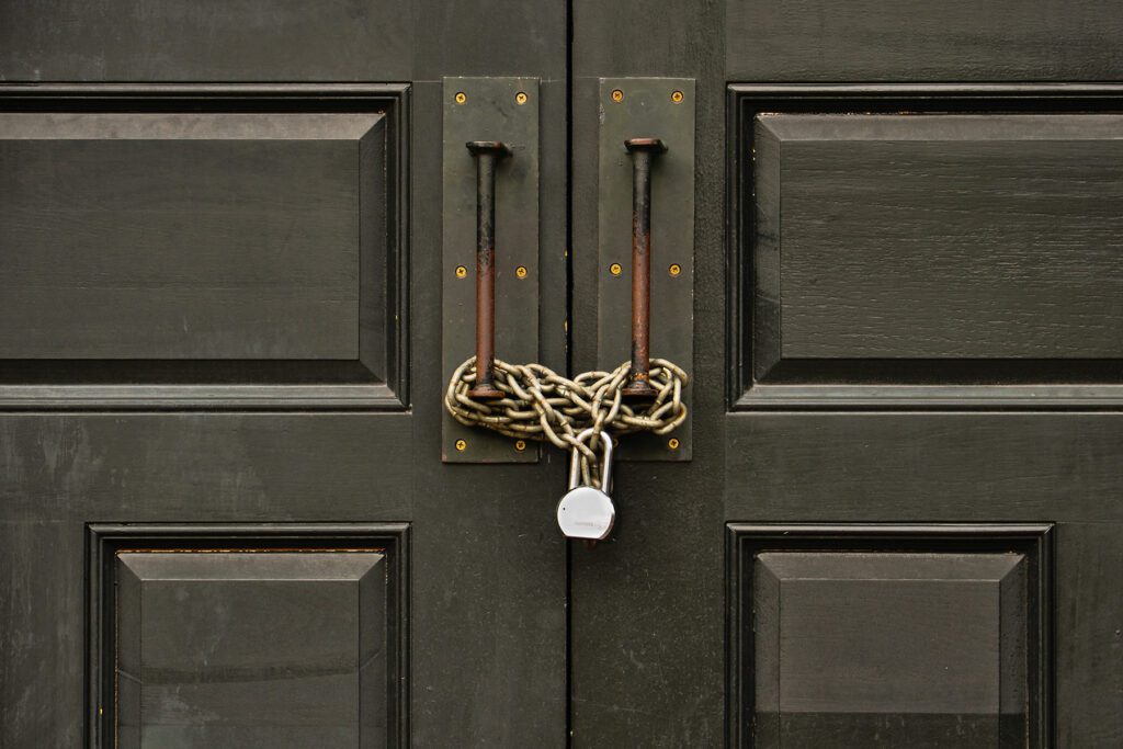 wooden door padlocked with a chain