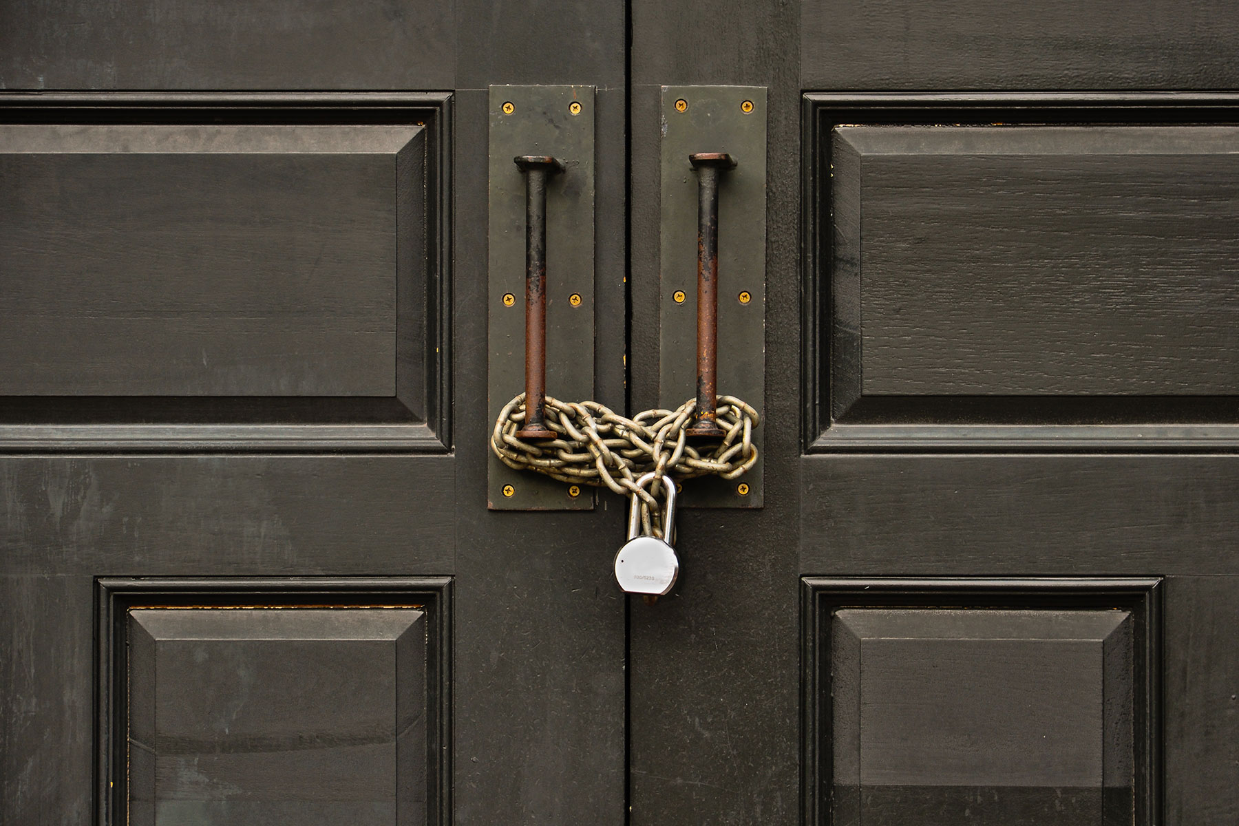 wooden door padlocked with a chain