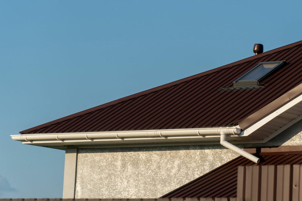 This suburban home exterior showcases a brown corrugated metal roof with a skylight.