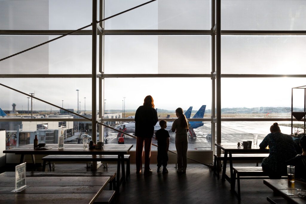 Family stood watching planes in airport terminal
