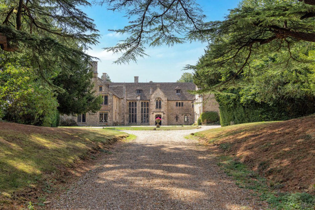 16th Century Chavenage House a Grade 1 listed building on August 8 2025, near Beaverston, Tetbury, The Cotswolds, Gloucestershire, United Kingdom. Viewed from public road.