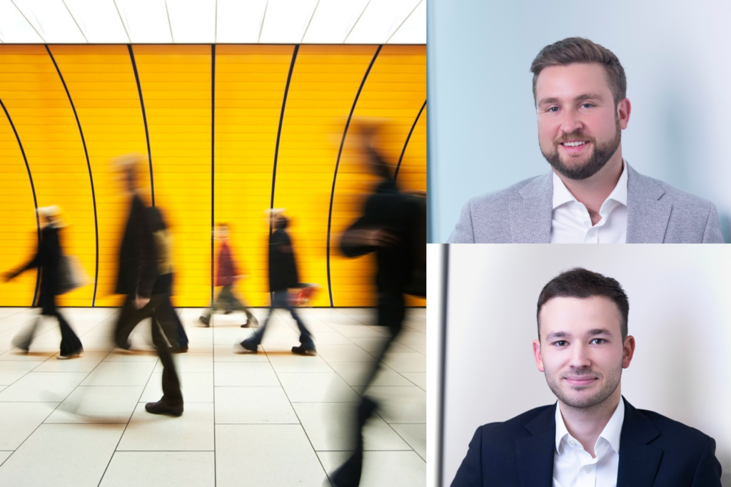 Blurred people walk past a bright yellow underground wall on the left; on the right are portraits of two smiling men in business attire against light backgrounds.