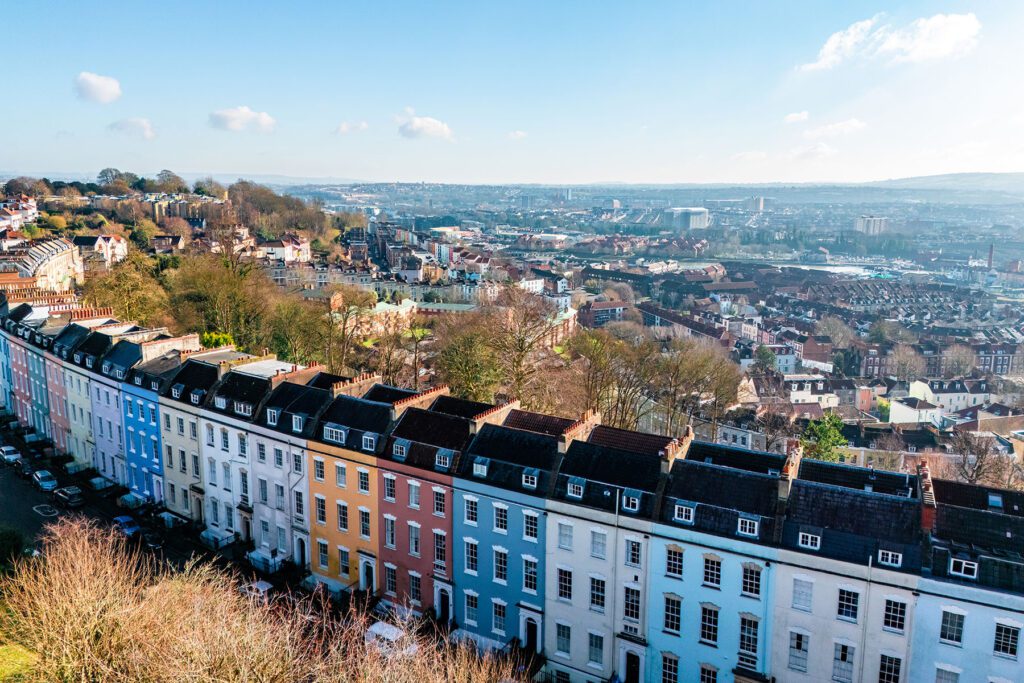Vibrant row houses line a hill with a panoramic view of bristol, showcasing the city's unique architecture and urban landscape