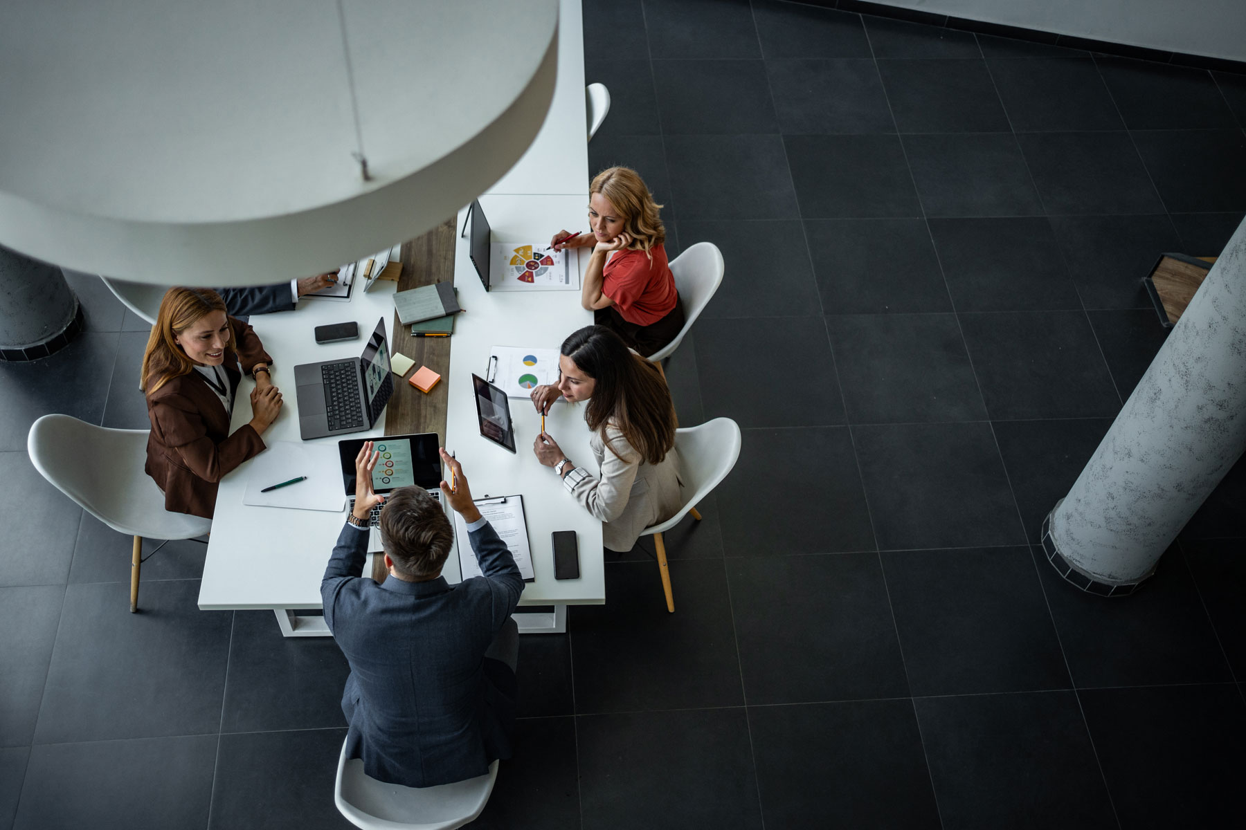 Group of business professionals collaborating and discussing data during a strategy meeting in a contemporary workspace