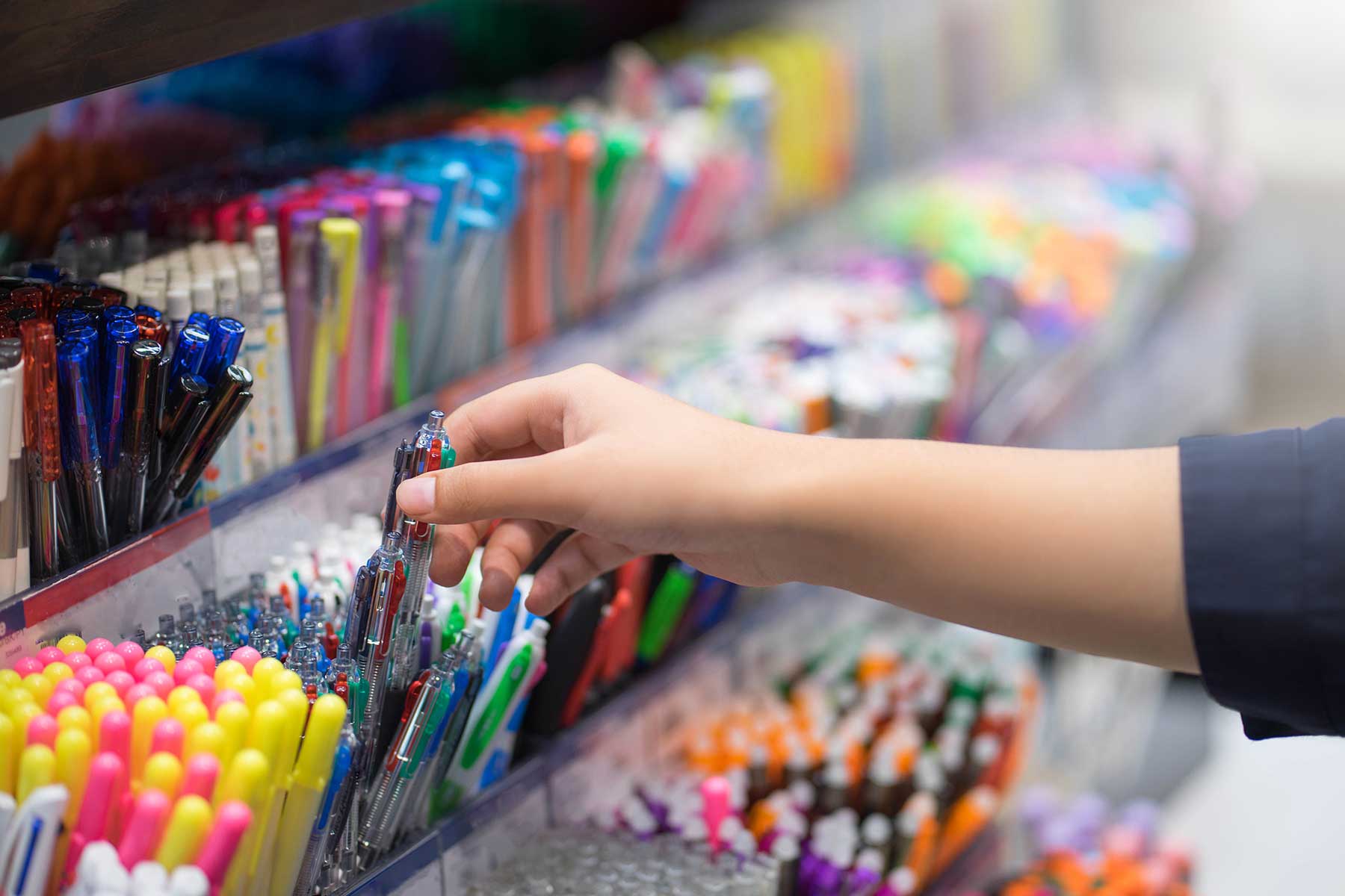 Close up hands choosing stationery in the supermarket.