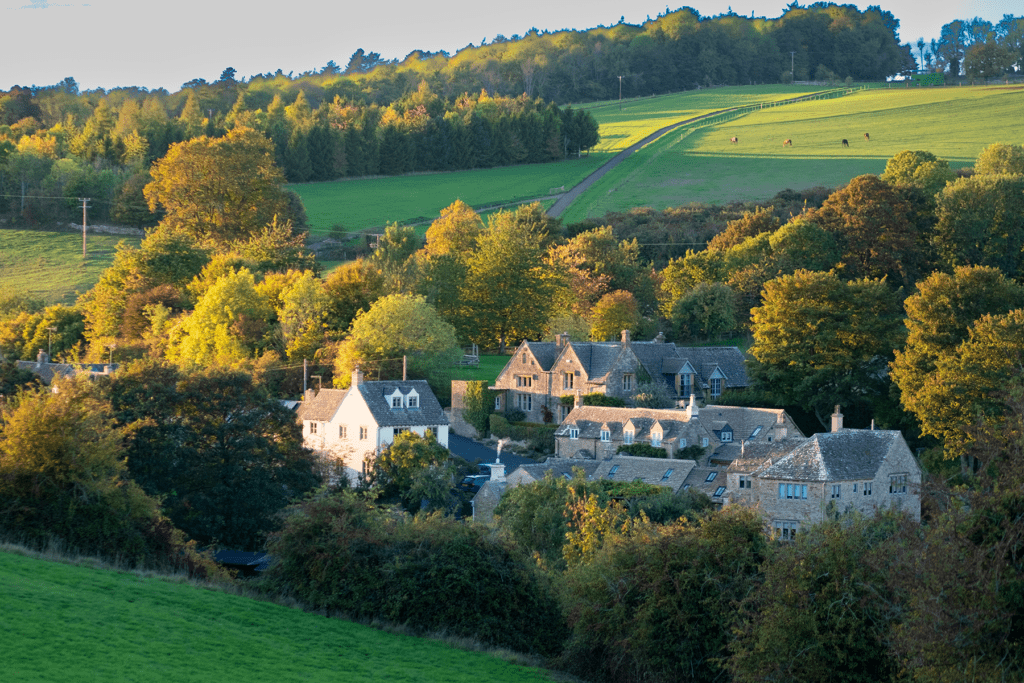 Beautiful typical traditional village in the green fields in the Cotswolds, England