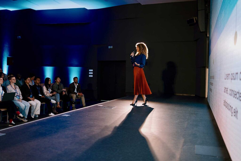 Professional speaker presenting on advancements at a technology event with engaged audience