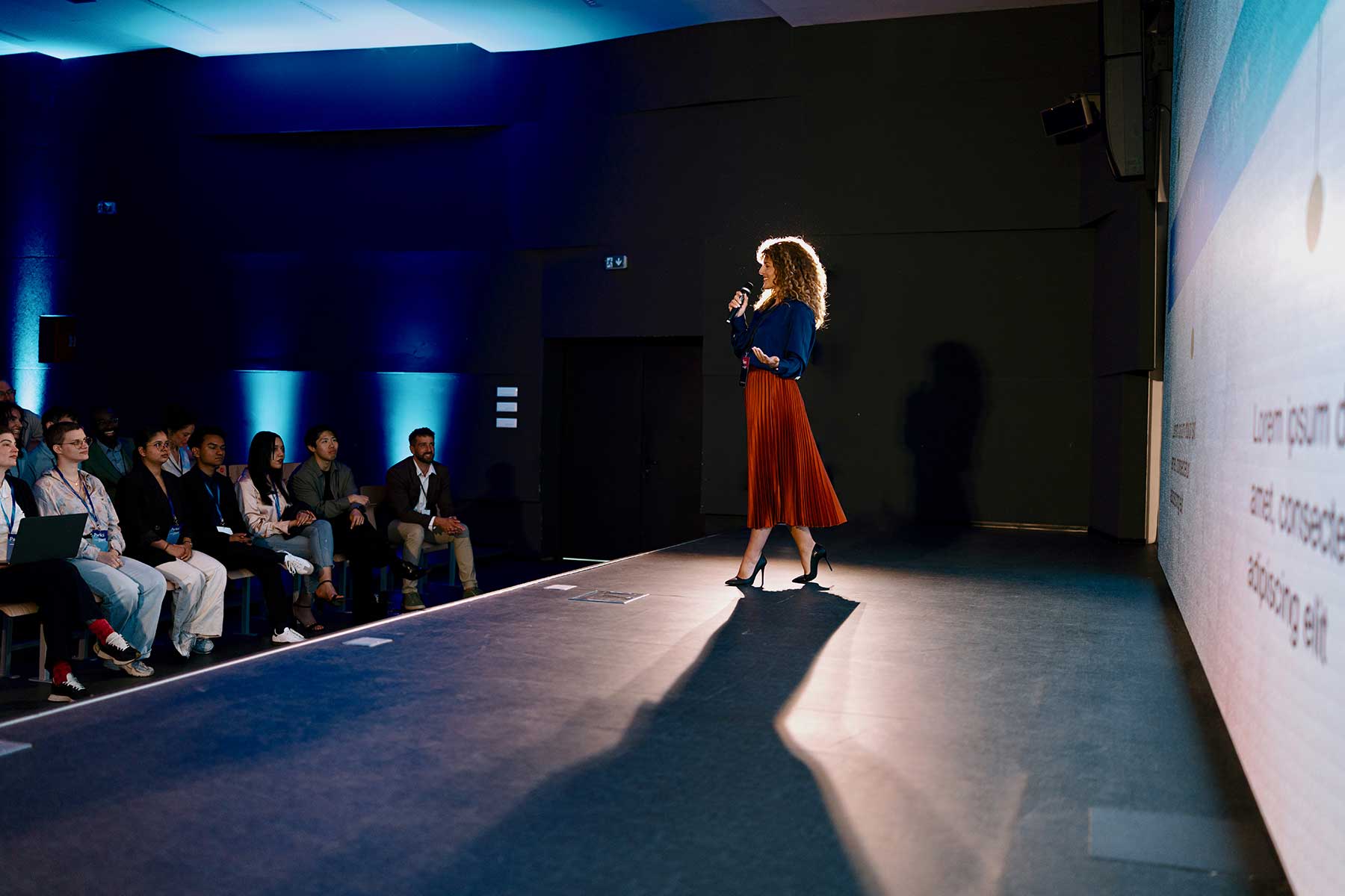 Professional speaker presenting on advancements at a technology event with engaged audience